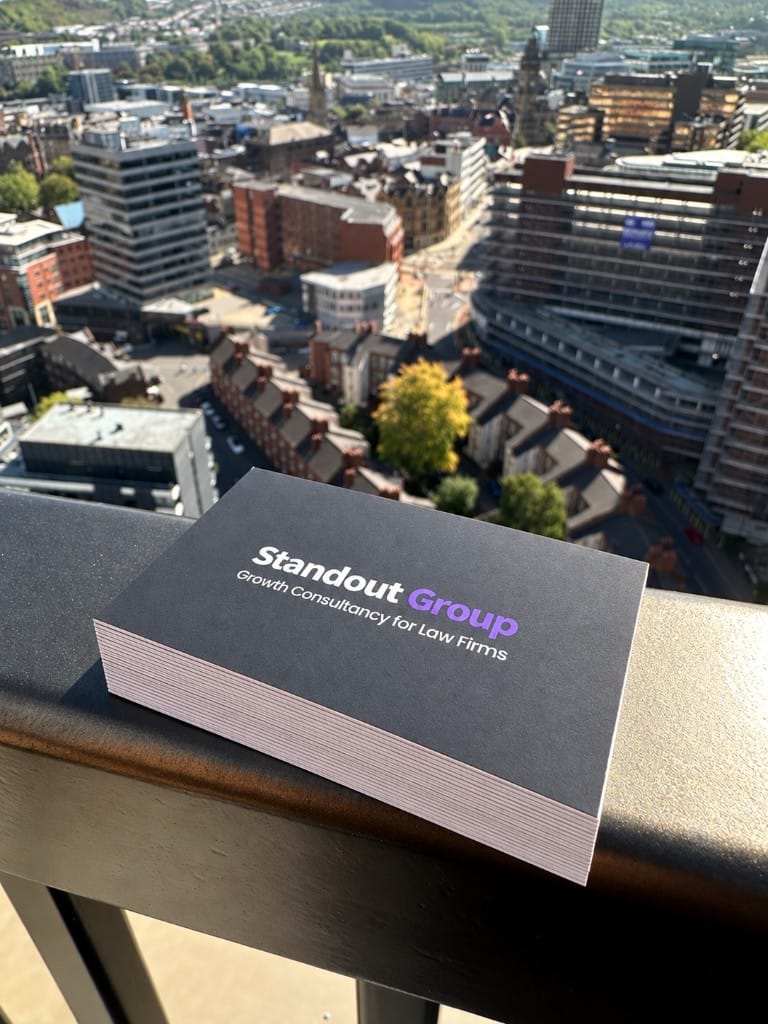 Standout Group business cards on a balcony overlooking the city.